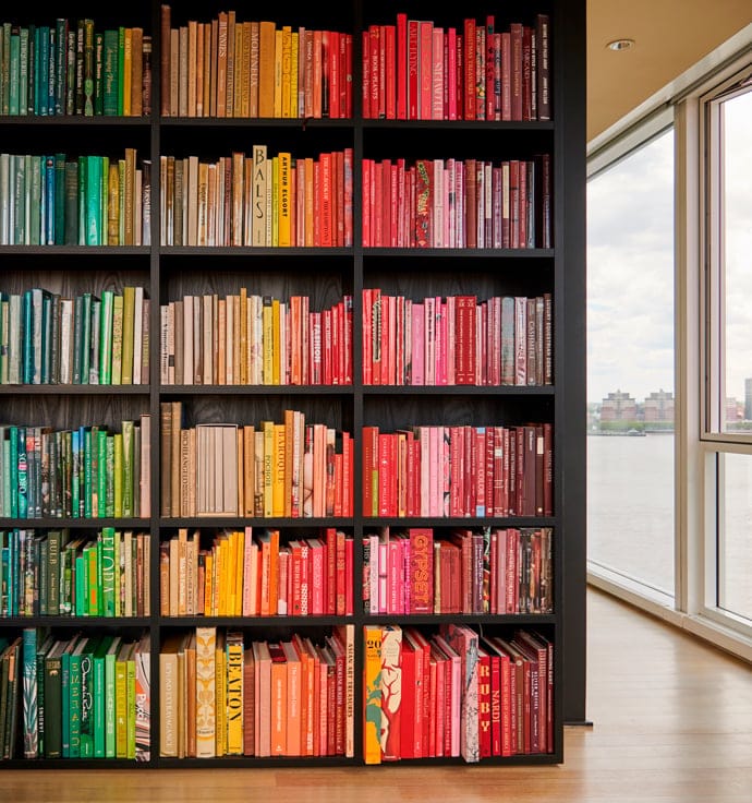 Custom bookshelves from floor to ceiling designs in dark wood grain finish by California Closets